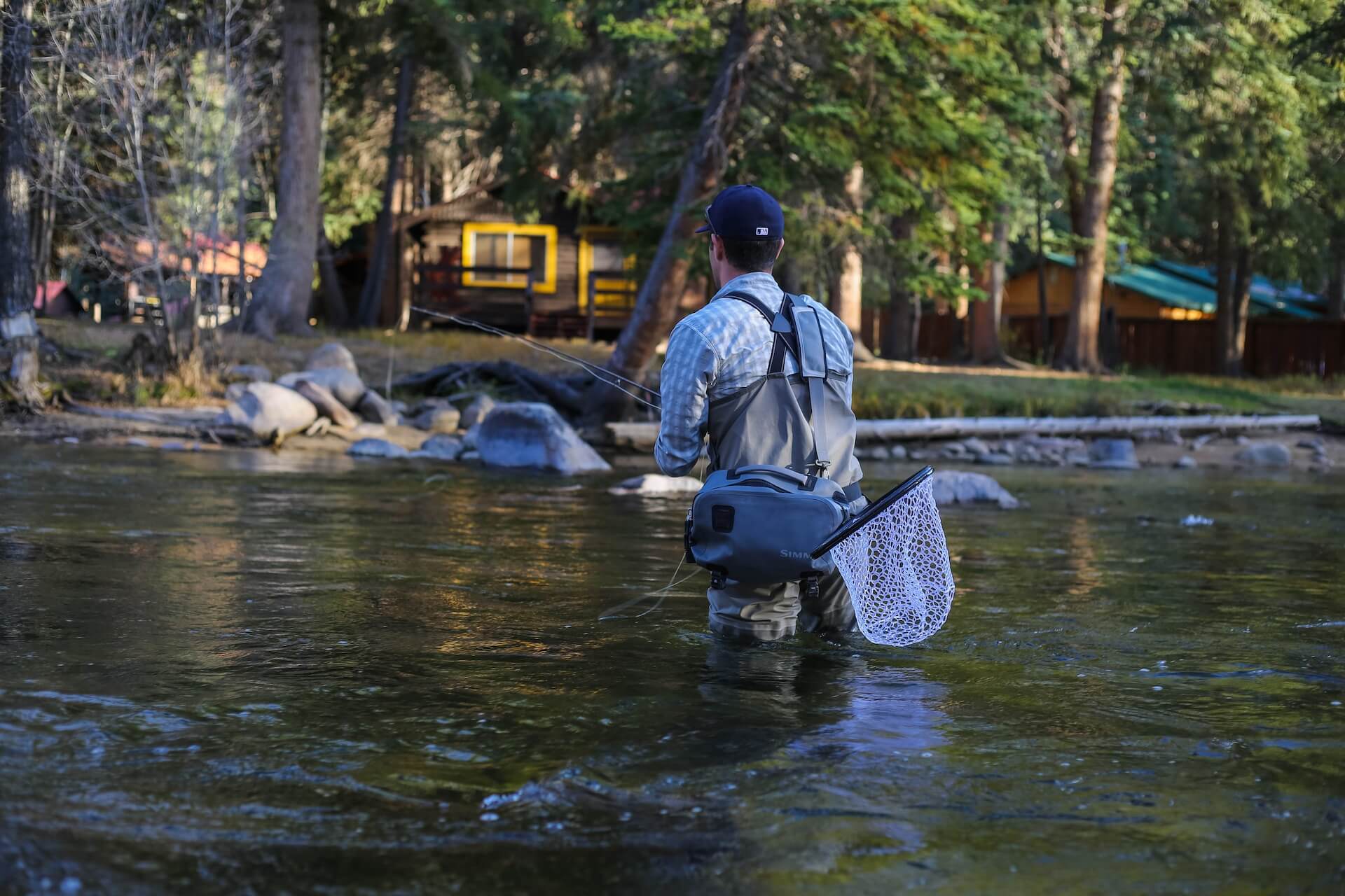 pêcheur en action avec des waders et des accessoires